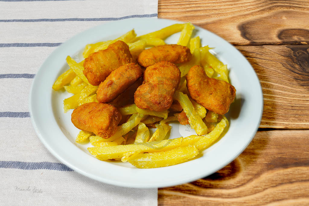 Encanta a los más pequeños con nuestro menú infantil, que incluye deliciosos nuggets con patatas en Restaurante Doña Juana, Granada.